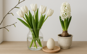 Skandinavische Frühlingsdekoration mit hellen Naturmaterialien, weißen Vasen und frischen Frühlingsblumen in minimalistischem Design